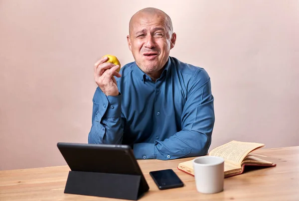 Şadamı Masasında Ekşi Bir Elma Yiyor Yüzünü Buruşturuyor — Stok fotoğraf