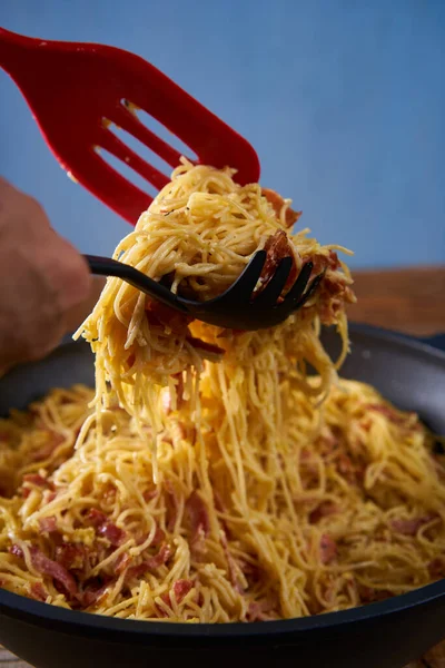 木製のトレイに鍋に豚肉ハムとパルメザンチーズとイタリアのカルボナーラパスタ — ストック写真