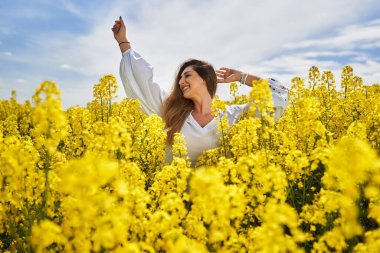 Çiçek açan kanola tarlasında güzel sarışın bir İspanyol kadının portresi.