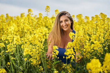 Çiçek açan kanola tarlasında güzel, şehvetli, sarışın İspanyol kadın, göz alıcı bir portre.