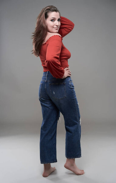 Studio portrait of a confident plus size young woman on gray background