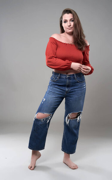 Studio portrait of a confident plus size young woman on gray background