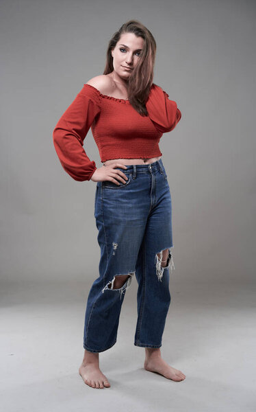 Studio portrait of a confident plus size young woman on gray background