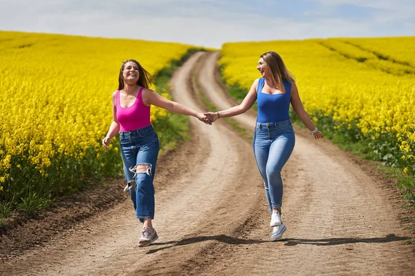 Két Plusz Méretű Barátnő Boldogan Sétál Földúton Egy Virágzó Reptéren — Stock Fotó