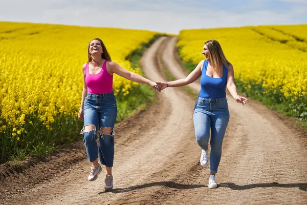 Twee Grote Vriendinnen Lopen Vrolijk Een Onverharde Weg Door Een — Stockfoto