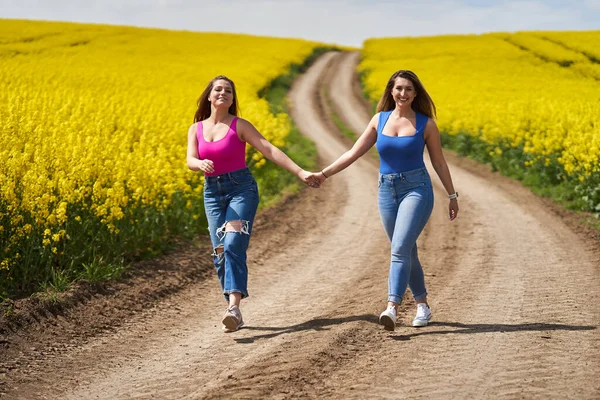 Két Plusz Méretű Barátnő Boldogan Sétál Földúton Egy Virágzó Reptéren — Stock Fotó