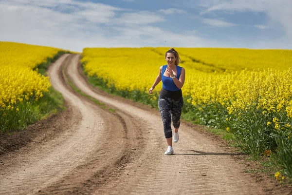 Size Beautiful Latin Woman Jogging Dirt Road Canola Field — Stock Photo, Image