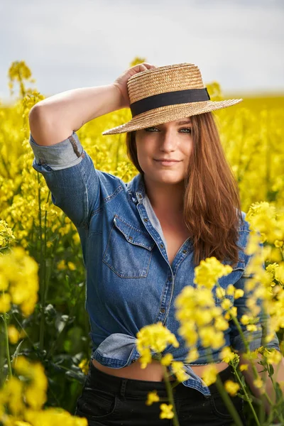 閉鎖ポートレートの美しいですCaucasianブロンド女性とともに青目でA菜の花畑で満開 — ストック写真