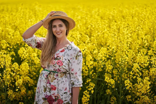 Portré Egy Gyönyörű Farmer Szalmakalapban Virágos Ruha Egy Virágzó Repce — Stock Fotó