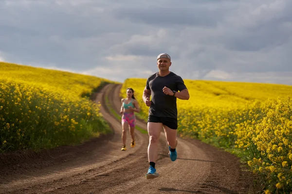 Couple Runners Running Hilly Course Dirt Track Canola Field — Stock Photo, Image