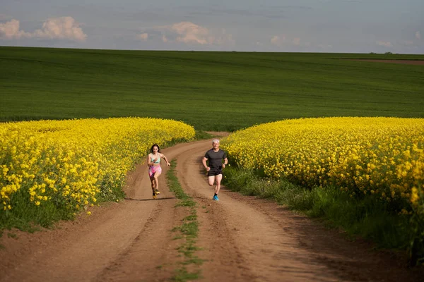 Ein Läuferpaar Läuft Auf Einer Hügeligen Strecke Auf Einem Feldweg — Stockfoto