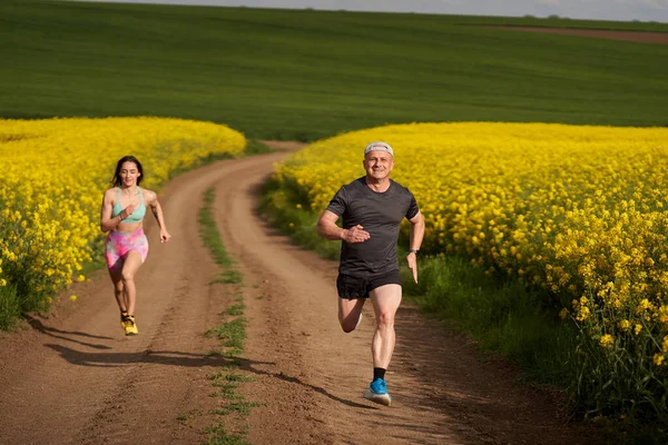 Ein Läuferpaar Läuft Auf Einer Hügeligen Strecke Auf Einem Feldweg — Stockfoto