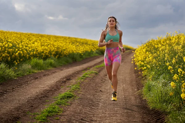 Corredor Mujer Joven Corriendo Una Pista Tierra Través Campo Canola — Foto de Stock