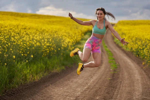 Žena Běžec Prašné Stezce Kanola Pole Dělá Nějaké Hloupé Skoky — Stock fotografie