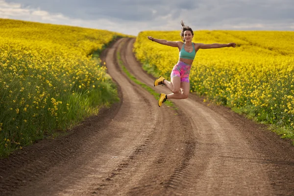 Woman Runner Dirt Trail Canola Field Doing Some Silly Jumps — Stock Photo, Image