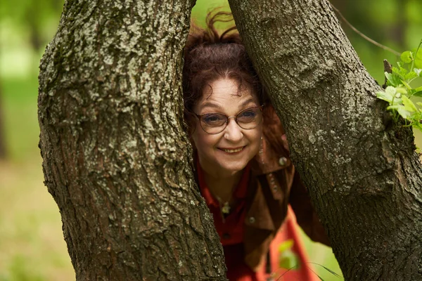 Игривая Взрослая Женщина Парке Застряла Между Двумя Деревьями — стоковое фото