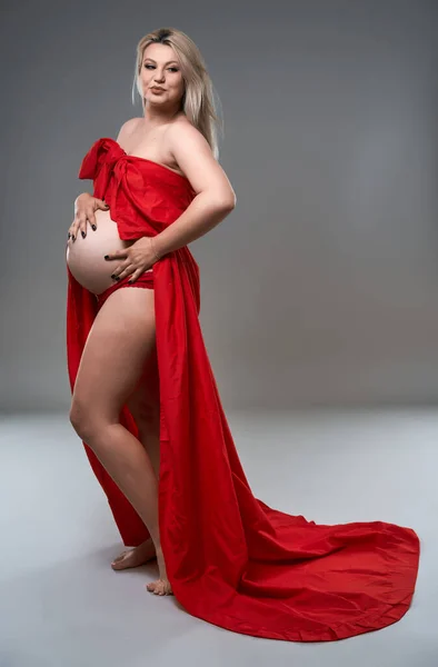 Gyönyörű Terhes Fiatal Szőke Piros Hullámos Lap Szürke Háttér — Stock Fotó