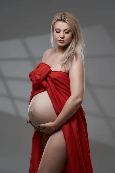 Beautiful Pregnant Young Blonde Woman Red Wavy Sheet Gray Background — Stock Photo, Image