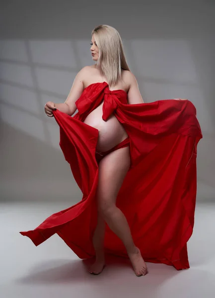 Vacker Gravid Ung Blond Kvinna Rött Vågigt Ark Grå Bakgrund — Stockfoto