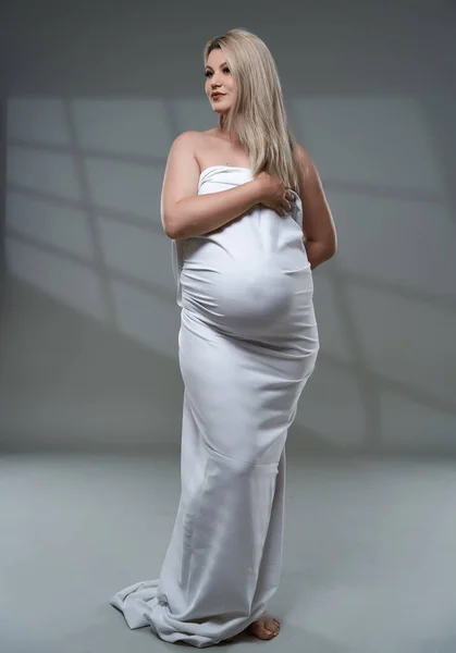 Mooie Zwangere Jonge Blonde Vrouw Wit Laken Grijze Achtergrond — Stockfoto