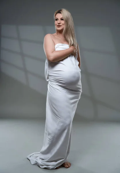 Krásná Těhotná Mladá Blondýna Žena Bílém Prostěradle Šedém Pozadí — Stock fotografie