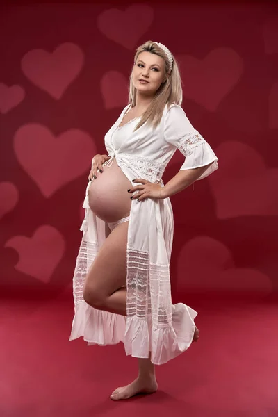 Hermosa Embarazada Joven Rubia Lencería Blanca Sobre Fondo Rojo — Foto de Stock