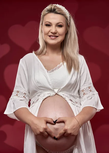 Kırmızı Arka Planda Beyaz Çamaşırlı Güzel Hamile Sarışın Kadın — Stok fotoğraf