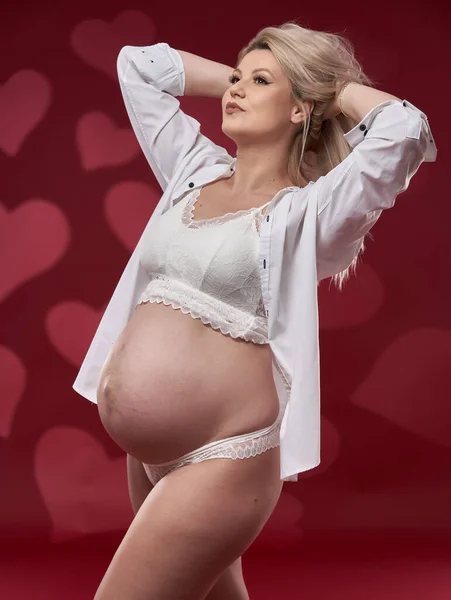 Mooie Zwangere Jonge Blonde Vrouw Wit Lingerie Rode Achtergrond — Stockfoto