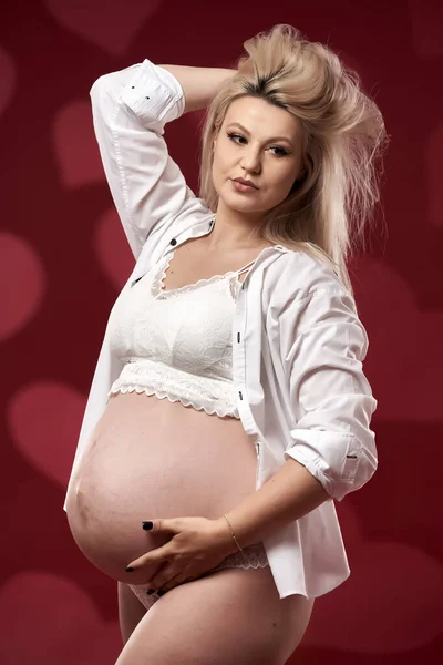 Frumos Gravidă Tânără Blondă Femeie Lenjerie Albă Fundal Roșu — Fotografie, imagine de stoc