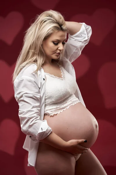 Hermosa Embarazada Joven Rubia Lencería Blanca Sobre Fondo Rojo —  Fotos de Stock