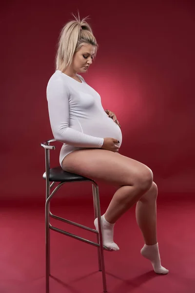 Hermosa Embarazada Joven Rubia Lencería Blanca Posando Sobre Fondo Rojo — Foto de Stock