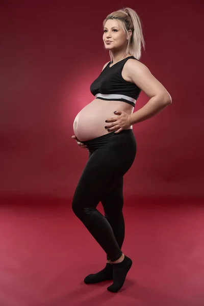 Schöne Schwangere Junge Blonde Frau Schwarzer Kleidung Studioaufnahme Auf Rotem — Stockfoto