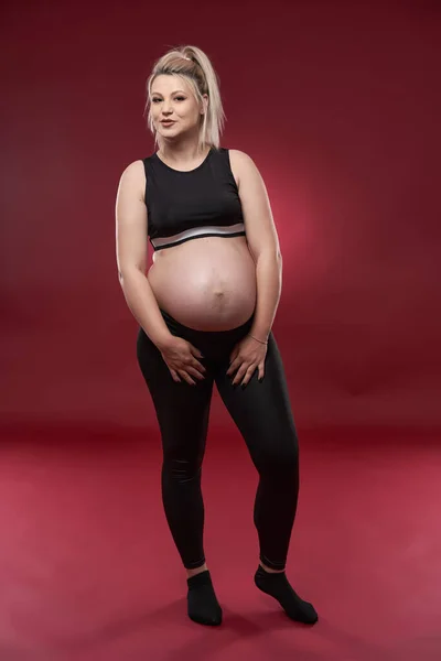 Όμορφη Έγκυος Νεαρή Ξανθιά Γυναίκα Μαύρα Ρούχα Στούντιο Πυροβόλησε Κόκκινο — Φωτογραφία Αρχείου