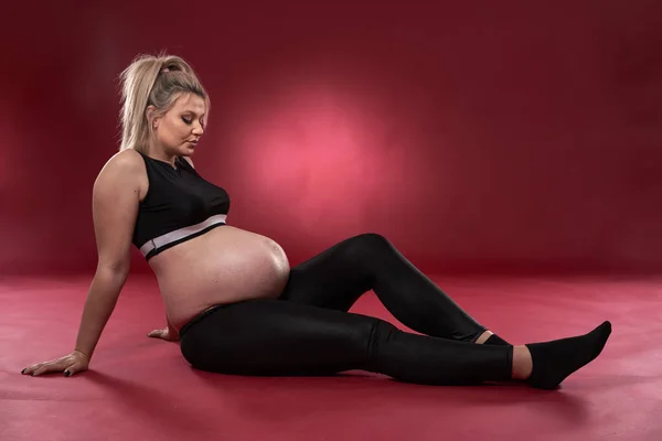 Siyah Elbiseli Güzel Hamile Sarışın Bir Kadın Kırmızı Arka Planda — Stok fotoğraf