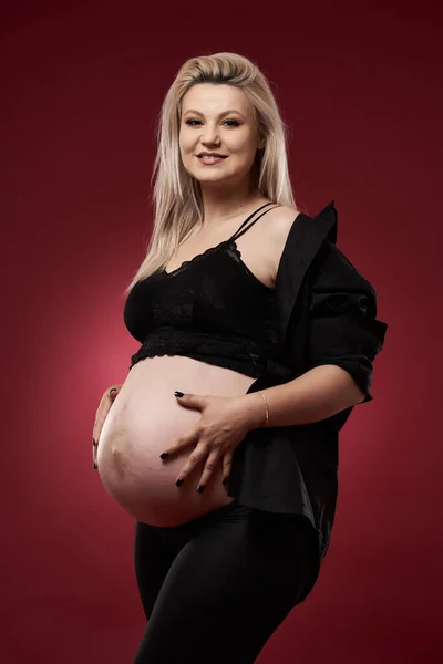 Siyah Elbiseli Güzel Hamile Sarışın Bir Kadın Kırmızı Arka Planda — Stok fotoğraf