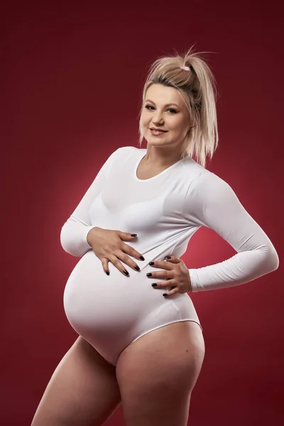 Gyönyörű Terhes Fiatal Szőke Fehér Fehérnemű Pózol Piros Háttér — Stock Fotó