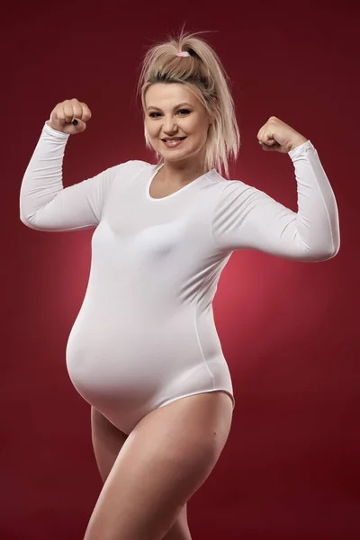 Krásná Těhotná Mladá Blondýna Žena Bílém Prádle Pózovat Červeném Pozadí — Stock fotografie