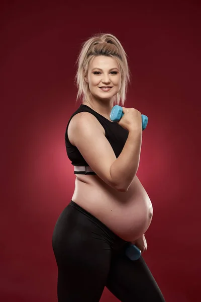 Tineri Gravidă Face Exerciții Fitness Fundal Roșu Studio Shot — Fotografie, imagine de stoc