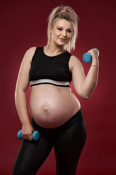 Genç Hamile Bir Kadın Kırmızı Arka Planda Spor Yapıyor Stüdyo — Stok fotoğraf