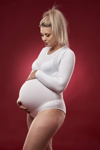 Vacker Gravid Ung Blond Kvinna Vita Underkläder Poserar Röd Bakgrund Stockbild