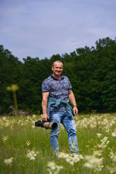 Profesionální Fotograf Přírody Terénu Lesa Drží Fotoaparát Dlouhým Teleobjektivem — Stock fotografie