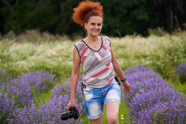 在薰衣草场拍摄的照片中 自然女摄影师拿着相机 — 图库照片