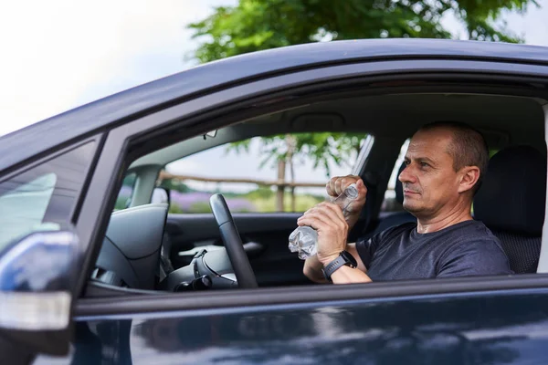 熱波の温度で車の中の男 飲料水 — ストック写真