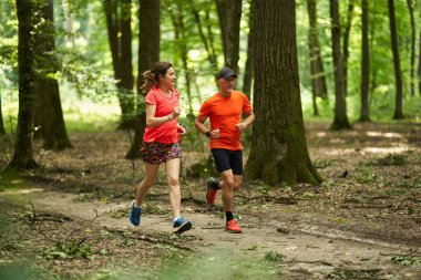Koşucular orman yolunda koşan çifte dayanıklılık gösterirler.              