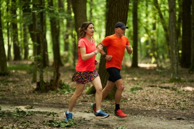 Koşucular orman yolunda koşan çifte dayanıklılık gösterirler.              
