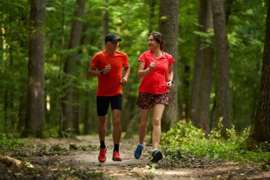 Koşucular orman yolunda koşan çifte dayanıklılık gösterirler.      