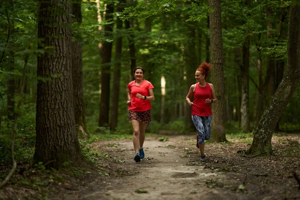Duas Mulheres Felizes Saudáveis Correndo Uma Trilha Corrida Floresta — Fotografia de Stock