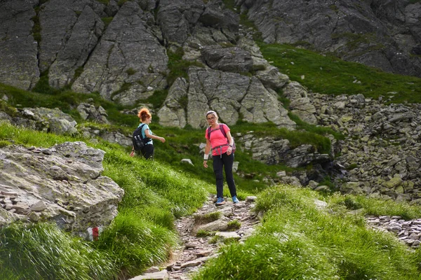 Twee Vrouwen Wandelaars Met Rugzakken Wandelen Een Pad Rotsachtige Bergen — Stockfoto