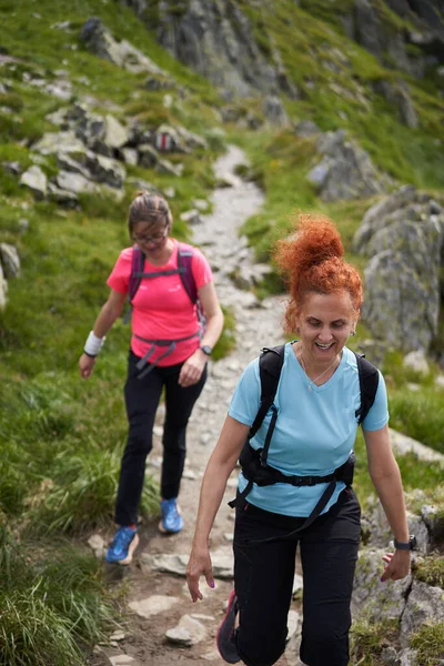 Dwie Piesze Kobiety Plecakami Wędrujące Ścieżką Skalistych Górach — Zdjęcie stockowe