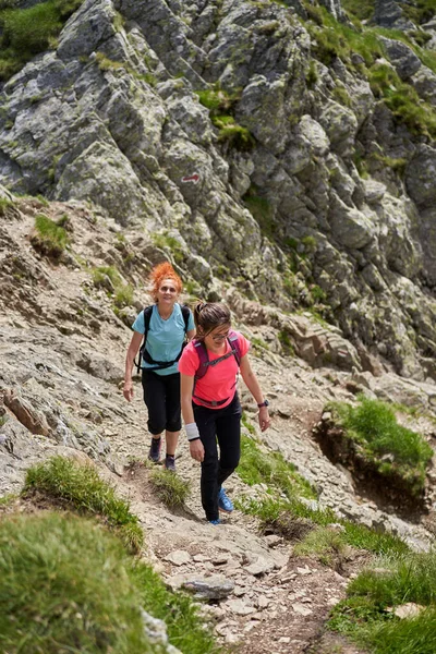Dwie Piesze Kobiety Plecakami Wędrujące Ścieżką Skalistych Górach — Zdjęcie stockowe